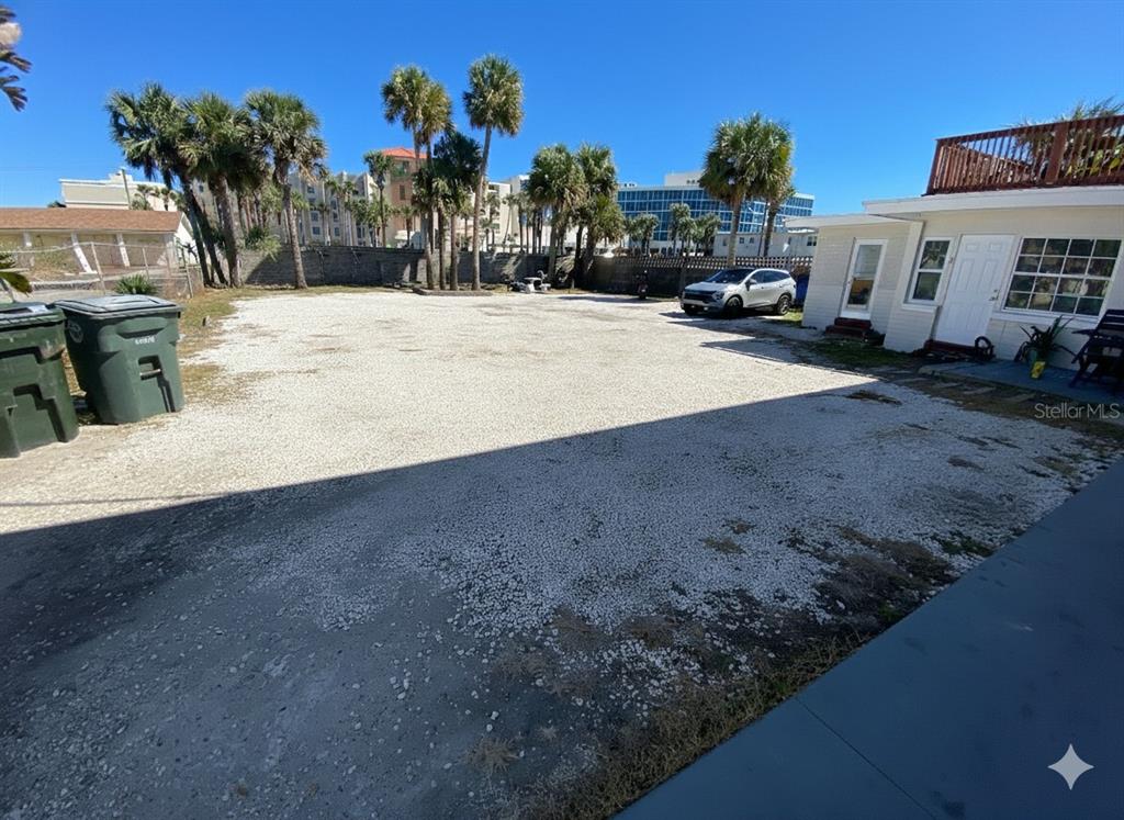 A gravel parking area sits in front of a small building with palm trees nearby — 938 N GRANDVIEW AVENUE, DAYTONA BEACH, FL
