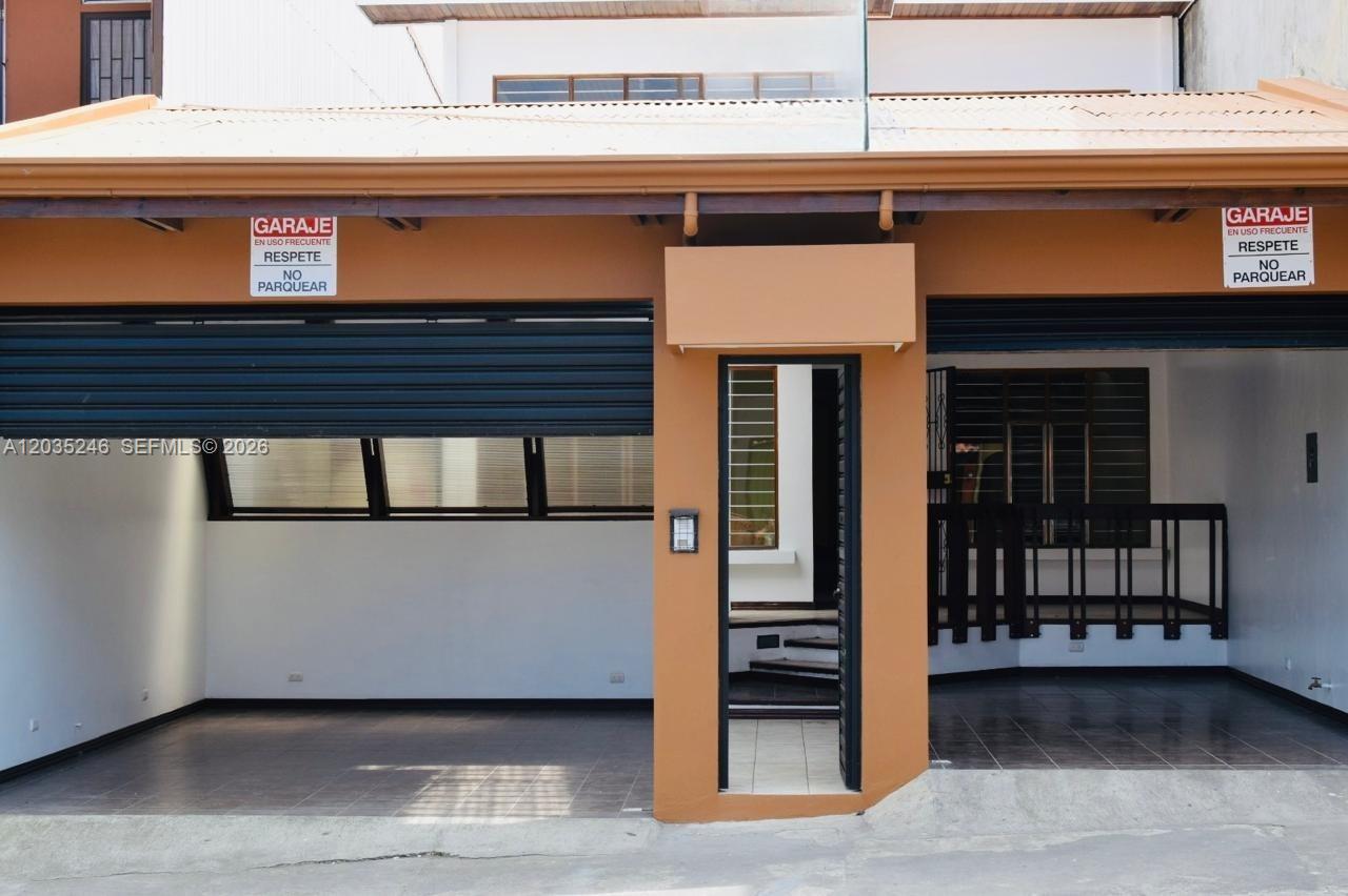 A house exterior features two garage bays with no-parking signs and a central pedestrian entrance — Cartago Cartago, FL, FL