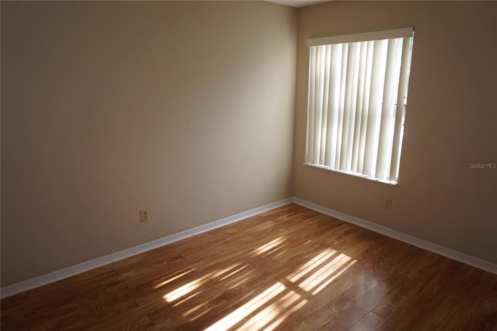 An empty room with light-colored walls, wood-look flooring, and a window with vertical blinds — 2749 N POINCIANA BOULEVARD UNIT 24, KISSIMMEE, FL