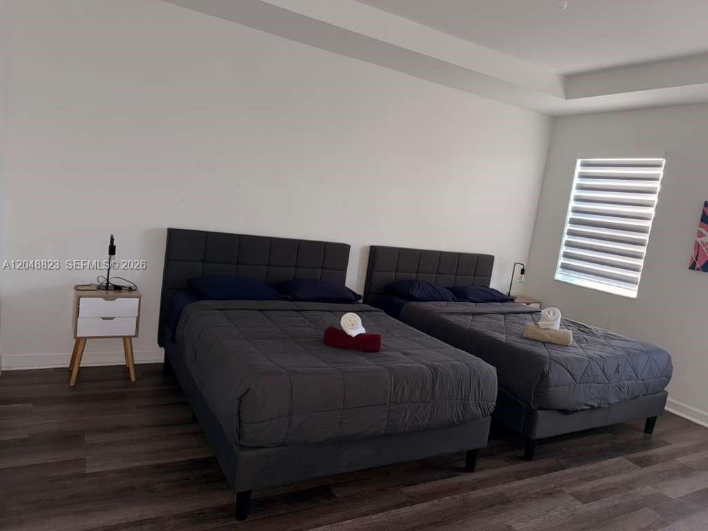 A bedroom features two dark gray beds with matching bedding and a white nightstand — 13623 SW 184th Ter, Miami FL 33177, MIAMI, FL