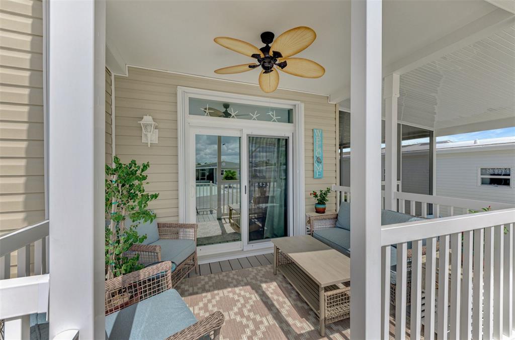 A covered porch features wicker furniture, a ceiling fan, and sliding glass doors — 804 TURF, VENICE, FL