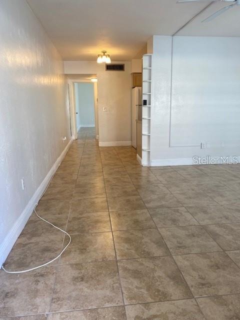 A view of a tiled room leading to a hallway with a doorway — 4565 DUHME ROAD UNIT 110, ST PETERSBURG, FL