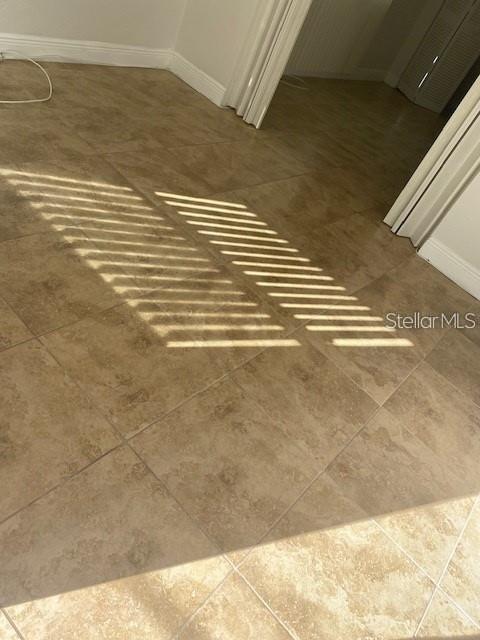 A room with tan tile flooring and light streaming through window blinds — 4565 DUHME ROAD UNIT 110, ST PETERSBURG, FL