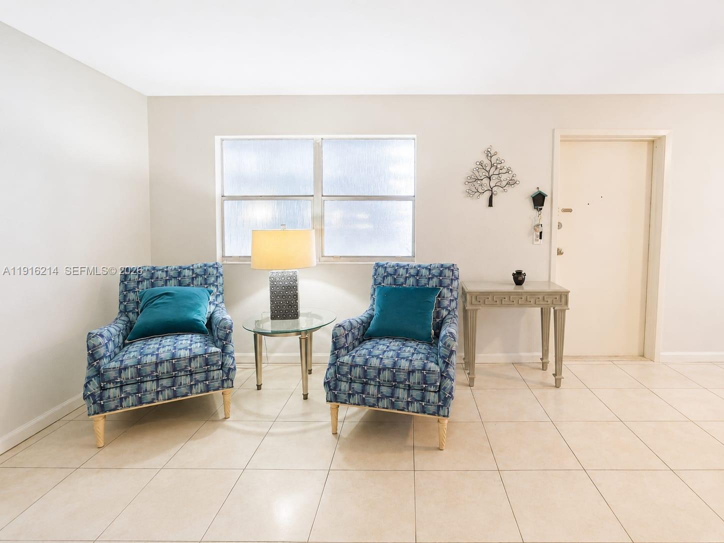 A room with two patterned blue armchairs, a glass side table, and a console table — 116 Tuscany B # 116, Delray Beach FL 33446, DELRAY BEACH, FL