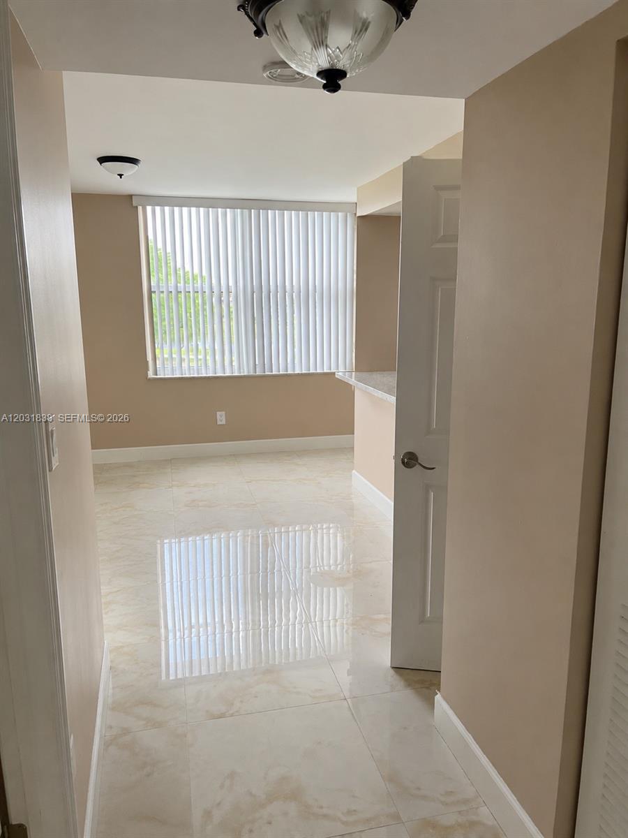 A tiled hallway leads into a room with a window covered by vertical blinds — 9420 Tangerine Pl # 401, Davie FL 33324, DAVIE, FL
