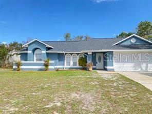 A blue single-story house with a white-trimmed exterior and a two-car garage — 1551 ORTEGA AVENUE, DELTONA, FL