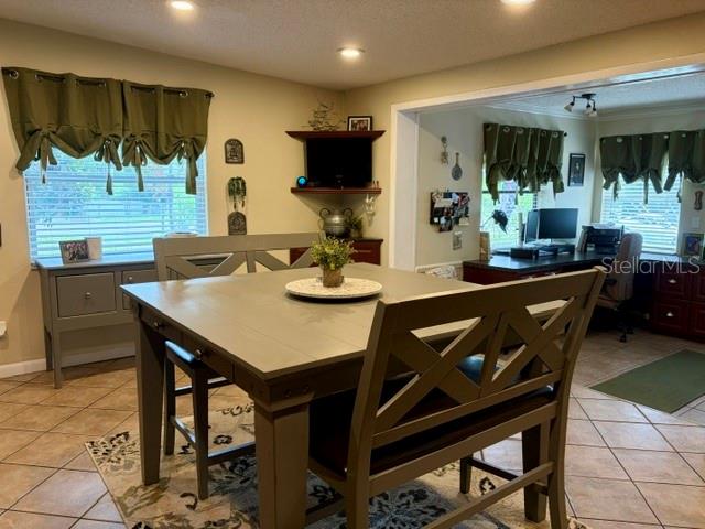 A dining area features a square wooden table with chairs and an adjacent home office — 915 HARBOR HILL DRIVE, SAFETY HARBOR, FL