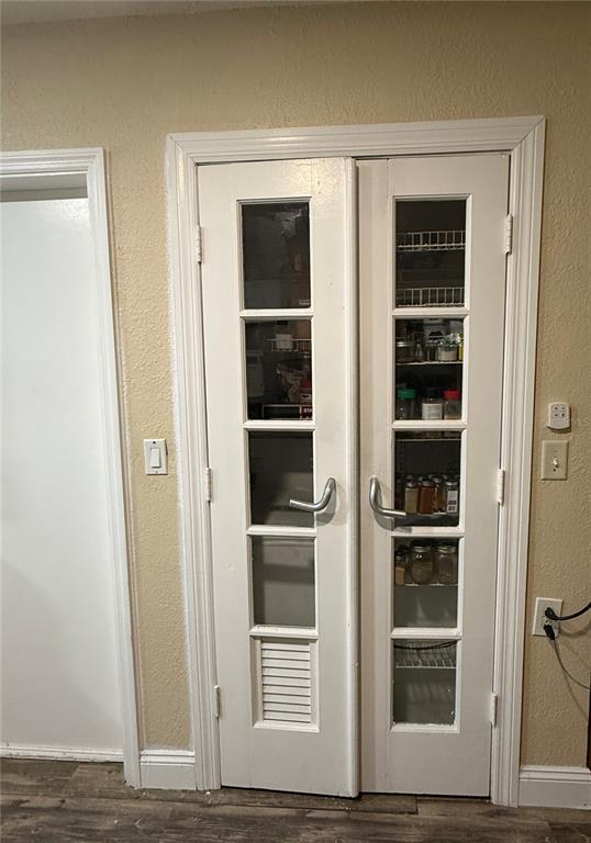 A set of white French doors with glass panels leads into a pantry with shelving — 1405 JACKSON AVENUE, DAYTONA BEACH, FL