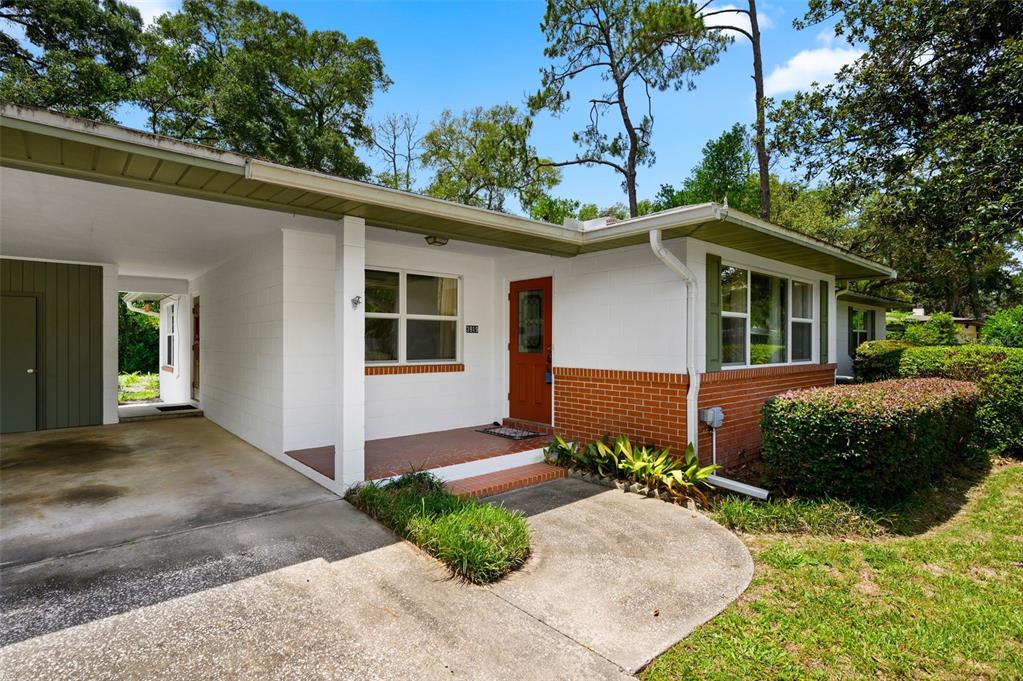A single-story house with a white block exterior, brick accents, and an attached carport — 3919 SW 4TH PLACE, GAINESVILLE, FL