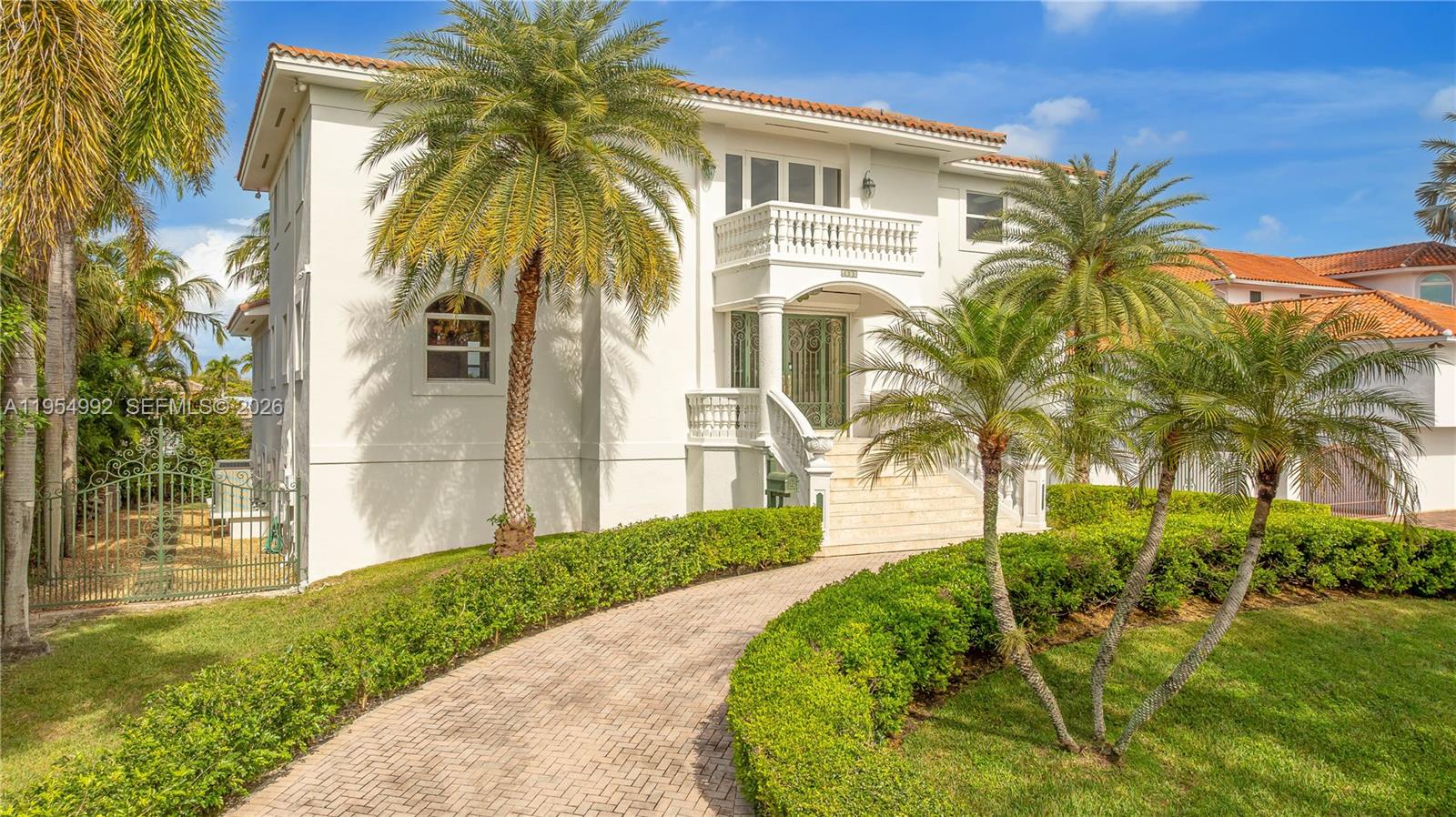 A multi-story white house with a tiled roof, palm trees, and a brick driveway — 6275 Dolphin Dr, Coral Gables FL 33158, CORAL GABLES, FL