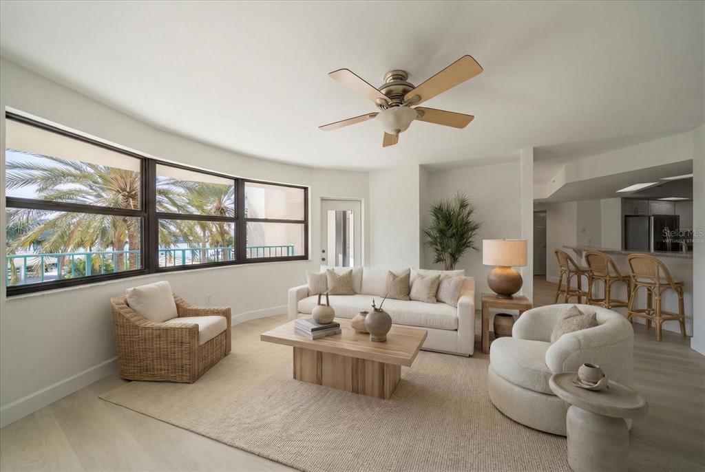 A dining room features a wooden table with six chairs, a sideboard, and a rug — 670 ISLAND WAY UNIT 304, CLEARWATER BEACH, FL