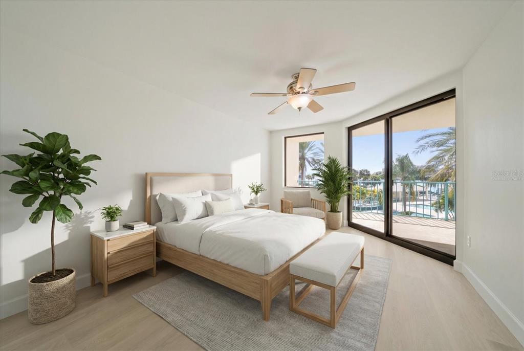 A bedroom with a bed, nightstand, bench, ceiling fan, and sliding doors opening to a balcony — 670 ISLAND WAY UNIT 304, CLEARWATER BEACH, FL