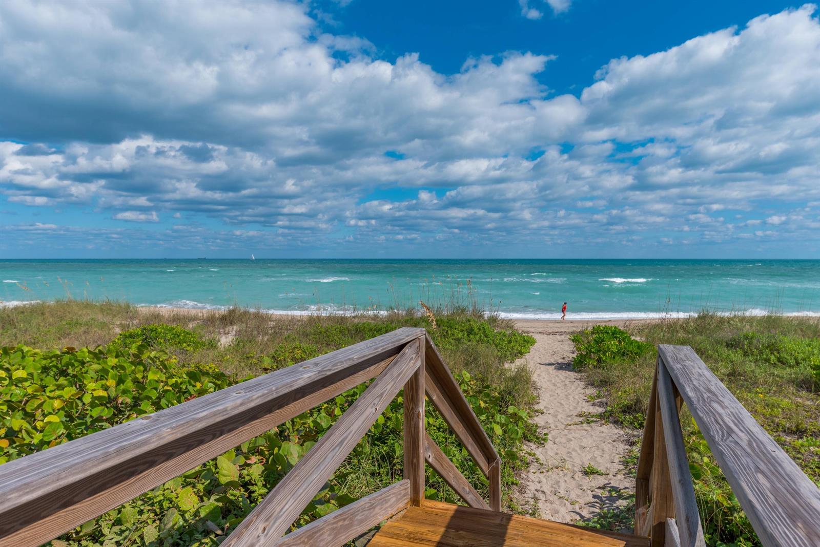 A wooden staircase leads down a sandy path toward a beach and the ocean — 4643 NE Ocean Boulevard, Jensen Beach FL 34957, JENSEN BEACH, FL