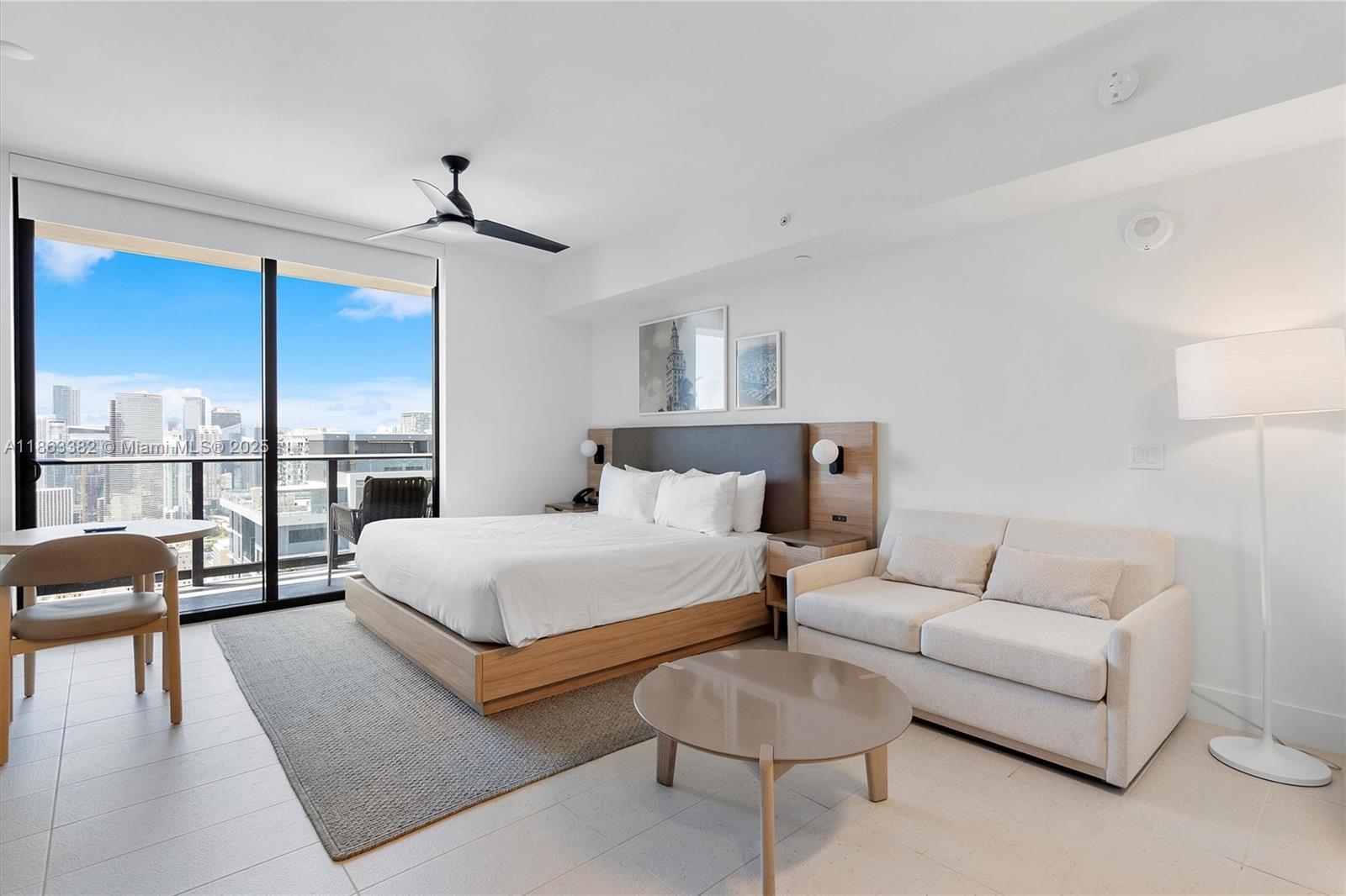A modern bedroom features a bed, sofa, coffee table, and a balcony with city views — 159 NE 6th St # 3806, Miami FL 33132, MIAMI, FL