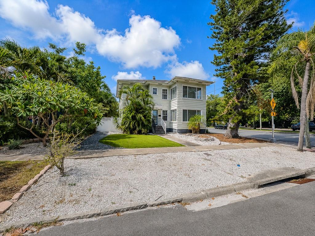 A two-story, light-colored house with a gravel front yard and a small patch of grass — 400 20TH STREET N, ST PETERSBURG, FL
