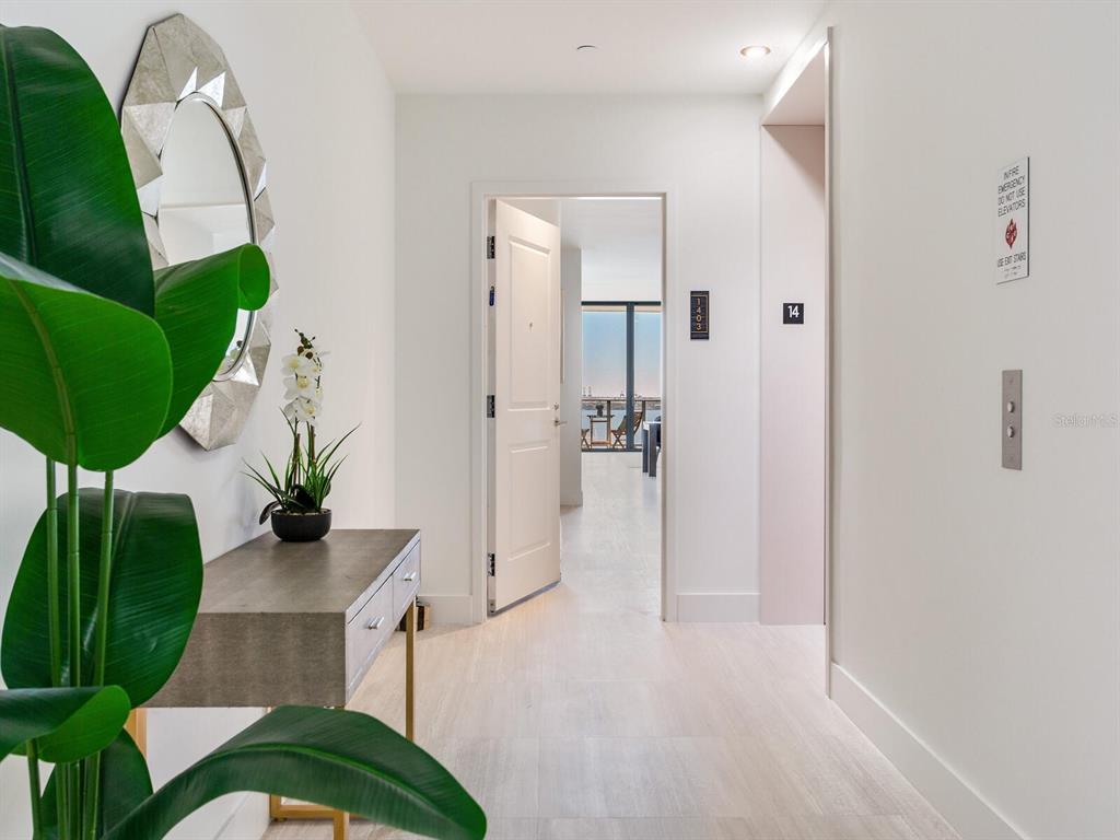 A hallway features a console table, a decorative mirror, and an open door to a balcony — 3015 S YSABELLA AVENUE UNIT 1403, TAMPA, FL