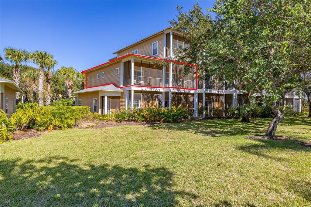A multi-story tan building features a screened-in balcony highlighted by a red outline — 612 RUM RUN UNIT 612, DAVENPORT, FL
