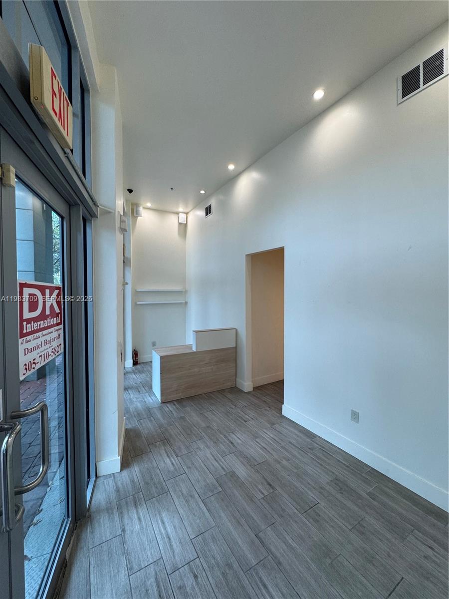 A small commercial space with wood-look tile flooring, white walls, and a reception desk — 110 Washington Ave # 7, Miami Beach FL 33139, MIAMI BEACH, FL