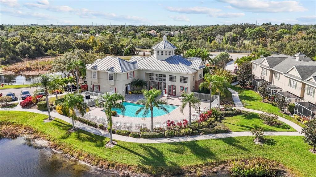 An aerial view shows a community clubhouse with a swimming pool surrounded by landscaped grounds — 7604 PLANTATION CIRCLE UNIT 7604, UNIVERSITY PARK, FL