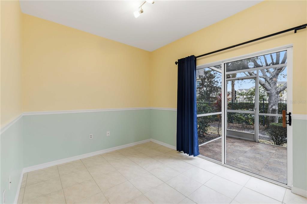A room with yellow and light green walls, tile floors, and a sliding glass door — 7604 PLANTATION CIRCLE UNIT 7604, UNIVERSITY PARK, FL