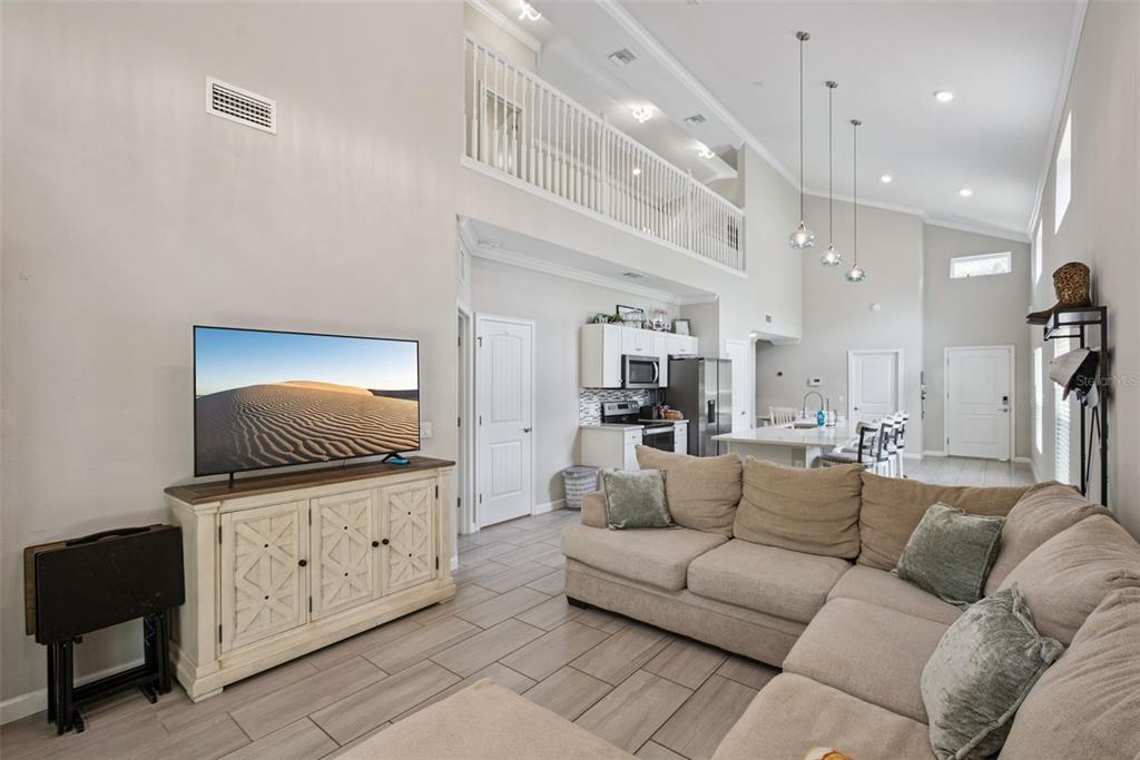 A living room with a sectional sofa, television console, and an open kitchen with island — 500 E EUCLID AVENUE, DELAND, FL