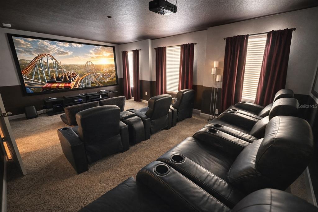 A home theater room features a large projection screen, multiple rows of leather reclining seats — 831 STICKS STREET, DAVENPORT, FL