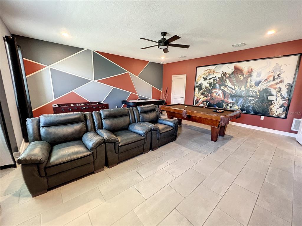 A game room features a pool table, foosball table, leather seating, and a large wall mural — 831 STICKS STREET, DAVENPORT, FL