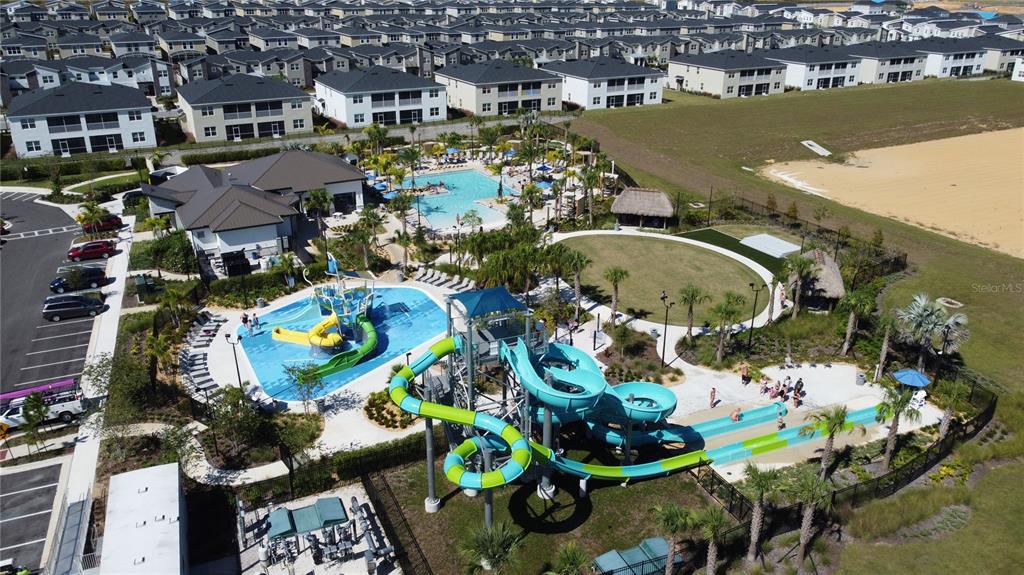 An aerial view shows a community pool complex with water slides and a splash pad — 831 STICKS STREET, DAVENPORT, FL