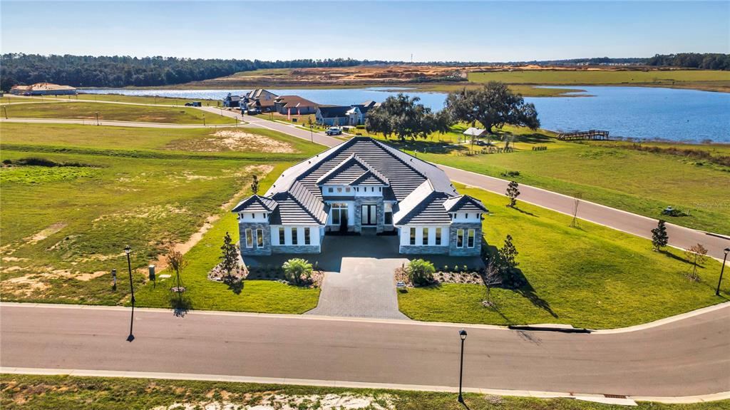 An aerial view shows a modern single-story house with a dark roof and stone facade — 35588 FARMVIEW ROAD, DADE CITY, FL