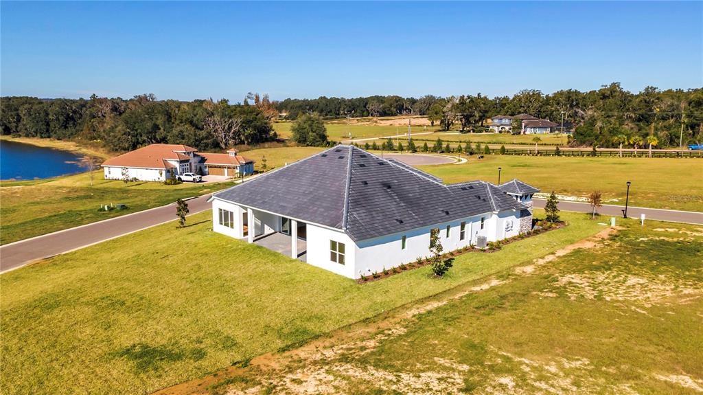 An aerial view shows a white house with a dark roof on a grassy lot — 35588 FARMVIEW ROAD, DADE CITY, FL