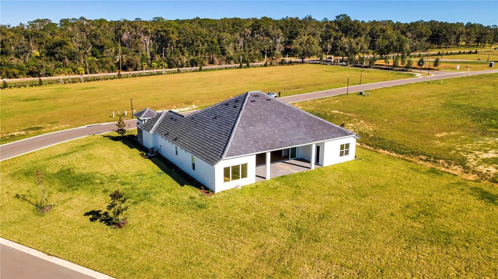 An aerial view shows a single-story white house with a dark roof on a lot — 35588 FARMVIEW ROAD, DADE CITY, FL