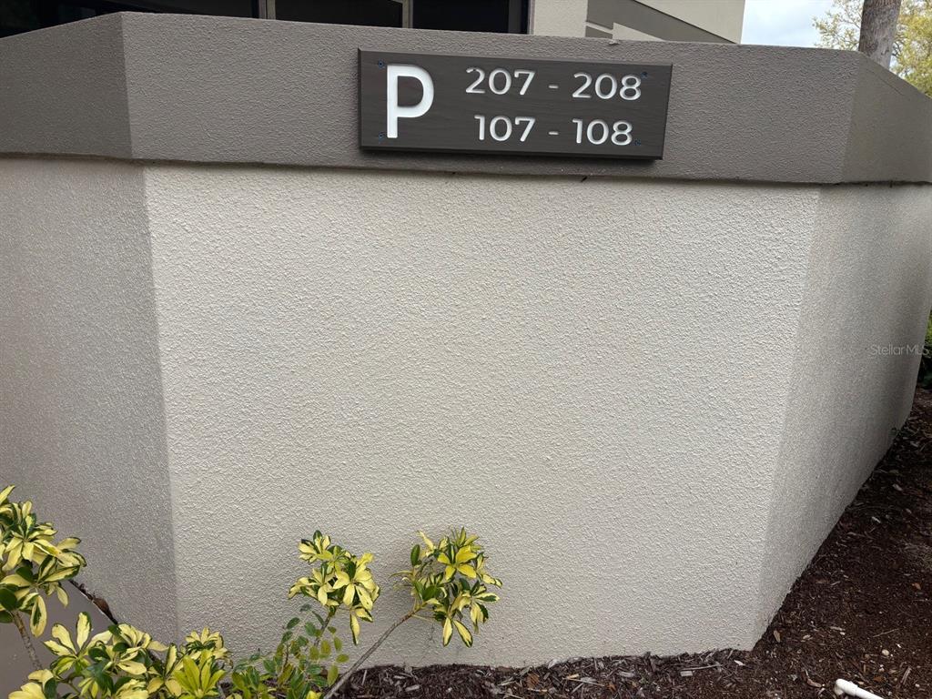 A sign labeled P indicates units 107, 108, 207, and 208 on a stucco building exterior — 1515 FORREST NELSON BOULEVARD UNIT P208, PORT CHARLOTTE, FL