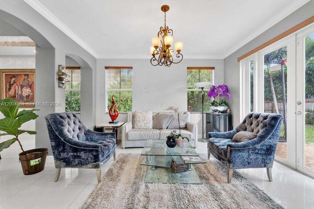 A living room features two blue velvet armchairs, a sofa, and a glass coffee table — 15465 SW 117th St, Miami FL 33196, MIAMI, FL