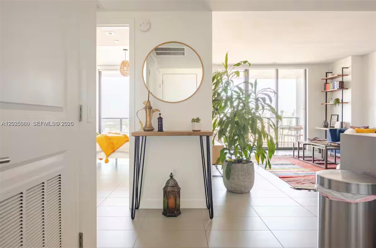 A console table with a mirror sits in an entryway leading to a living area — 1600 NE 1 AVE # 3519, Miami FL 33132, MIAMI, FL
