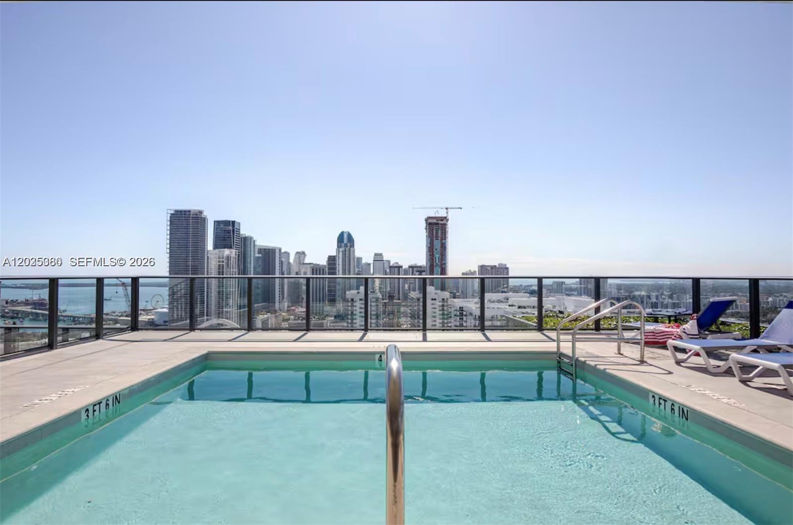 A rooftop swimming pool overlooks a city skyline and a body of water — 1600 NE 1 AVE # 3519, Miami FL 33132, MIAMI, FL