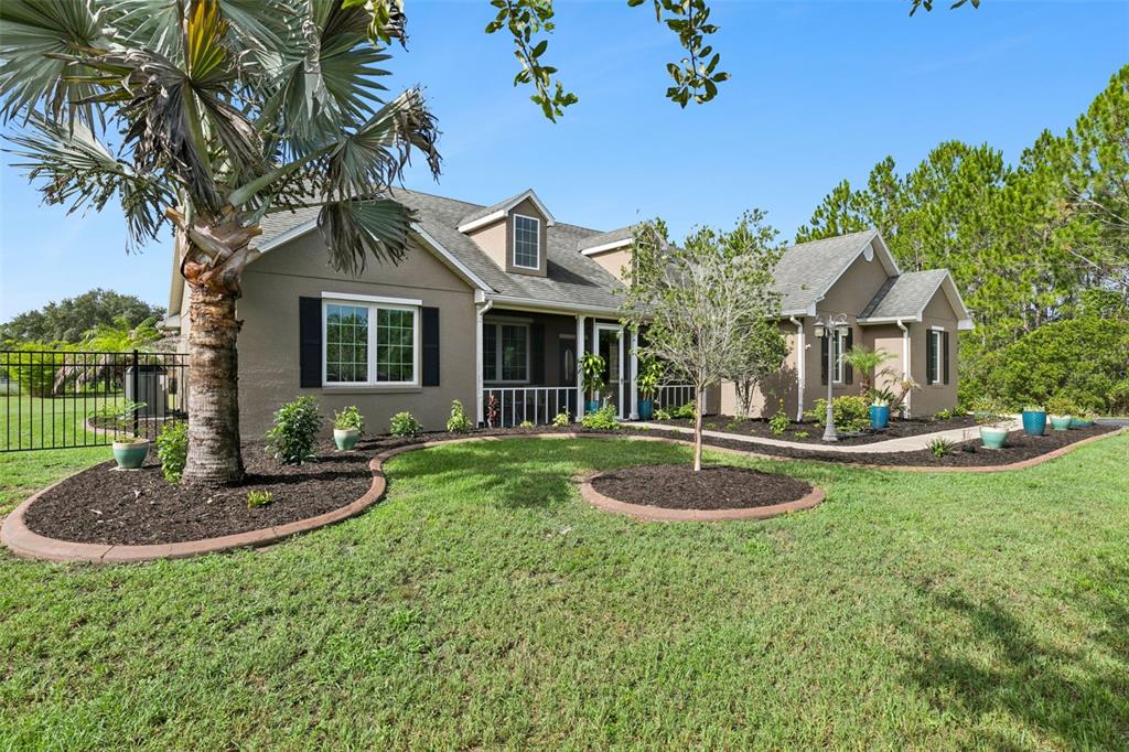 A single-story house with a tan exterior, dark shutters, and a landscaped front yard — 19204 PADDOCK STREET, ORLANDO, FL