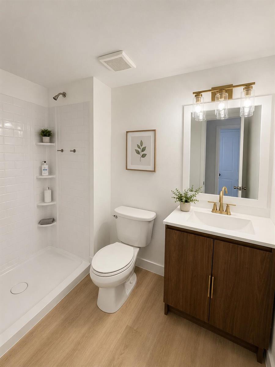 A modern bathroom features a walk-in shower, a white toilet, and a wood vanity — 4215 N University Drive # 112, Sunrise FL 33351, SUNRISE, FL