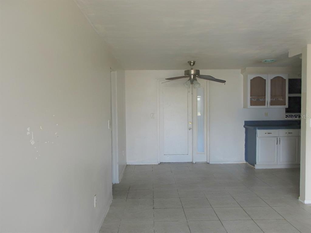 An interior view of a room with white walls, tile flooring, and a ceiling fan — 3024 WILLIAMSBURG STREET, SARASOTA, FL