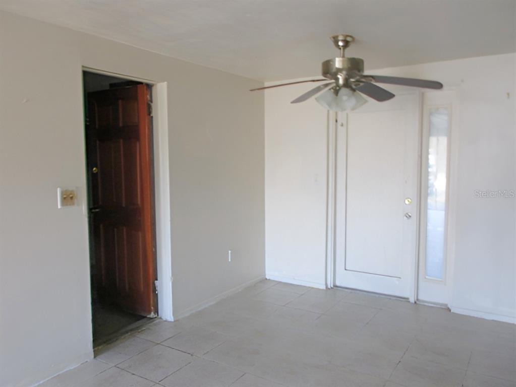 A room with light-colored tile flooring, a ceiling fan, and two doorways — 3024 WILLIAMSBURG STREET, SARASOTA, FL