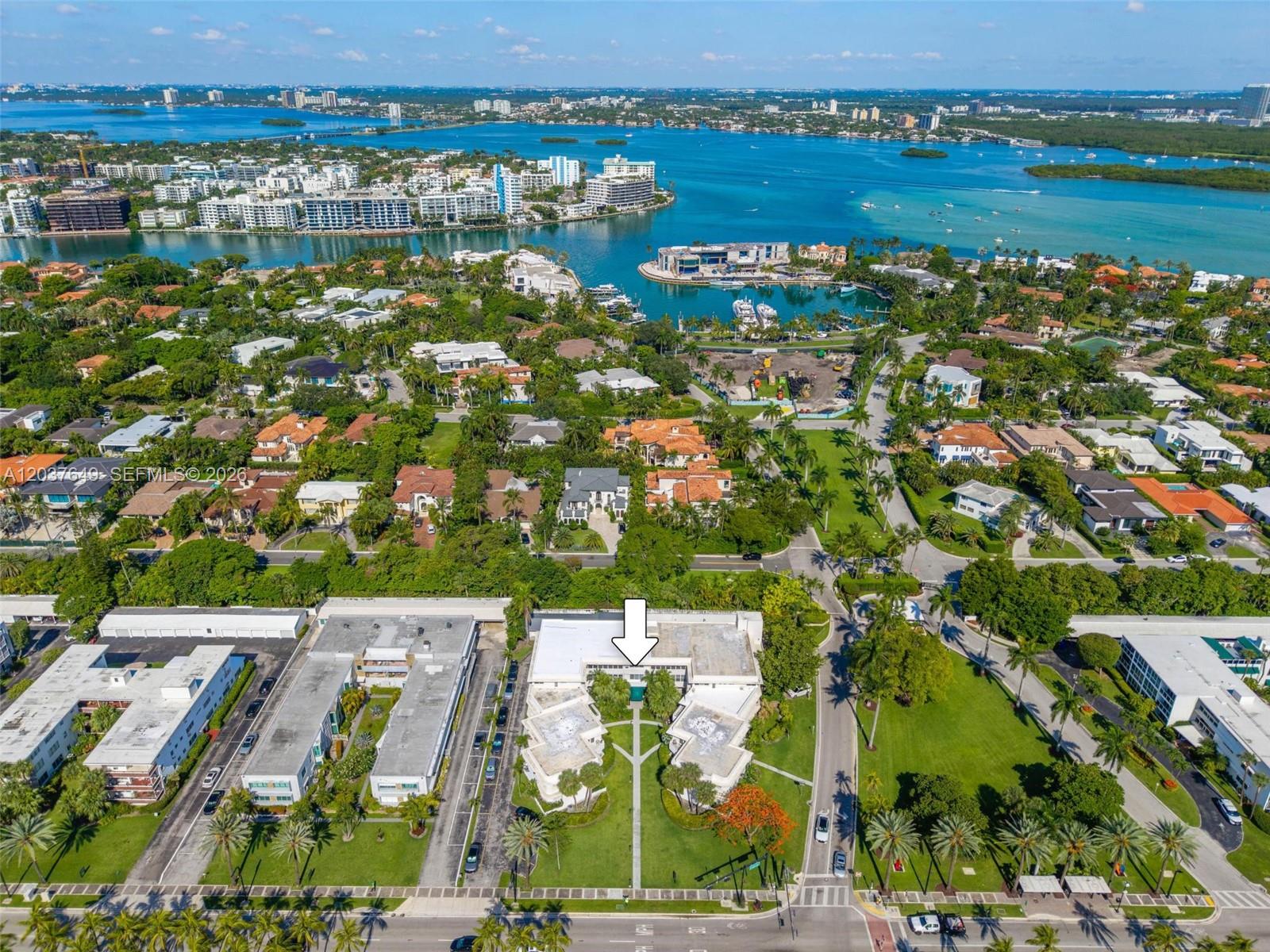 An aerial view shows a multi-story residential building complex surrounded by lush landscaping and water — 10190 Collins Ave # 107, Bal Harbour FL 33154, BAL HARBOUR, FL