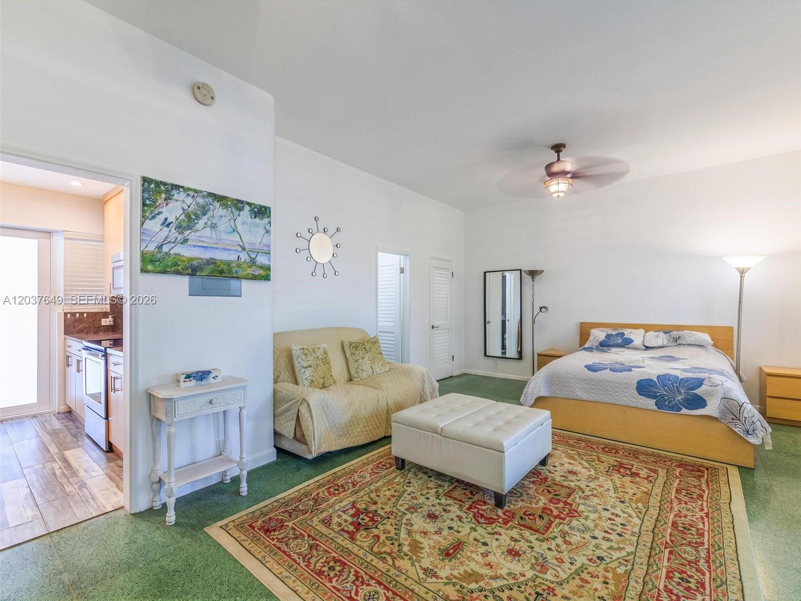 A bedroom features a bed, a small sofa, an ottoman, and an attached kitchen area — 10190 Collins Ave # 107, Bal Harbour FL 33154, BAL HARBOUR, FL