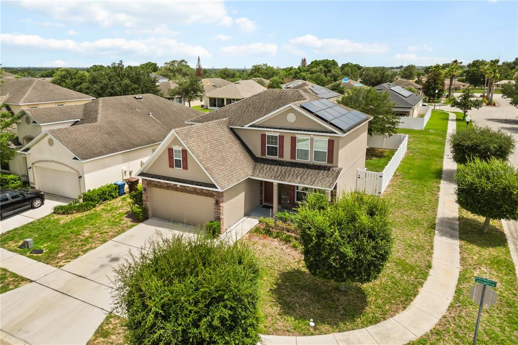 An aerial view shows a two-story suburban house with solar panels and a garage — 656 WASHINGTON WAY, HAINES CITY, FL