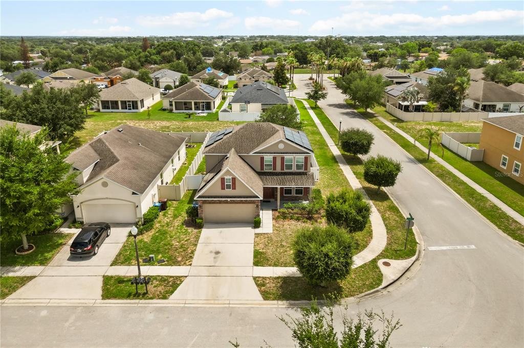 An aerial view shows a two-story suburban house with solar panels on the roof — 656 WASHINGTON WAY, HAINES CITY, FL