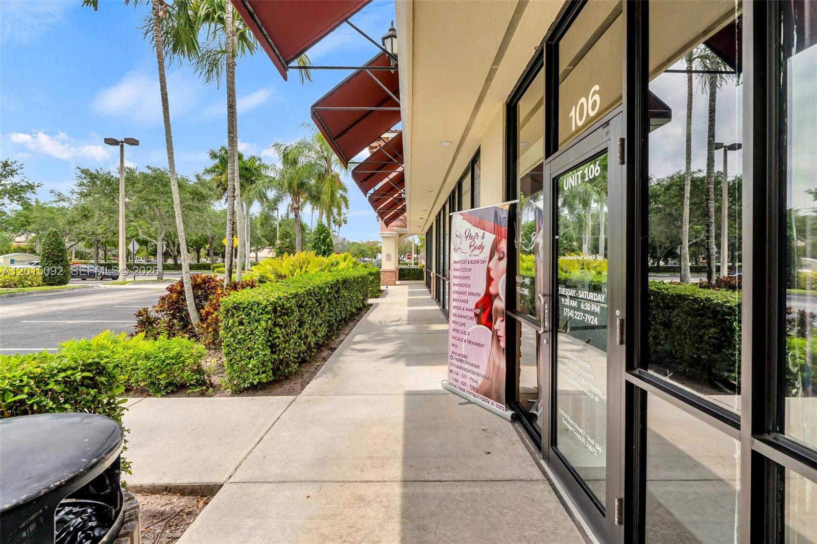 The exterior of a commercial storefront features a glass door, signage, and a sidewalk — 6370 N State Road 7, Coconut Creek FL 33073, COCONUT CREEK, FL