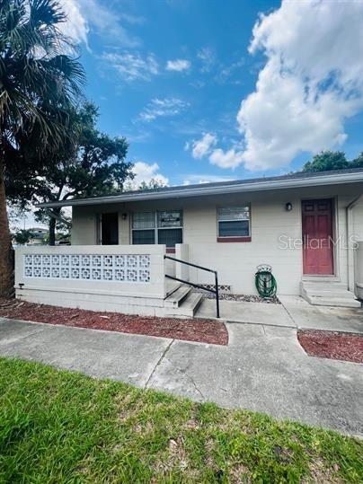 A single-story building exterior features a concrete porch with a decorative block wall and railing — 2075 HOWELL BRANCH ROAD UNIT 101, MAITLAND, FL