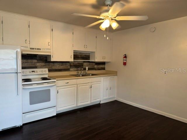 A kitchen features white cabinetry, a white stove, a dark backsplash, and a ceiling fan — 2075 HOWELL BRANCH ROAD UNIT 101, MAITLAND, FL