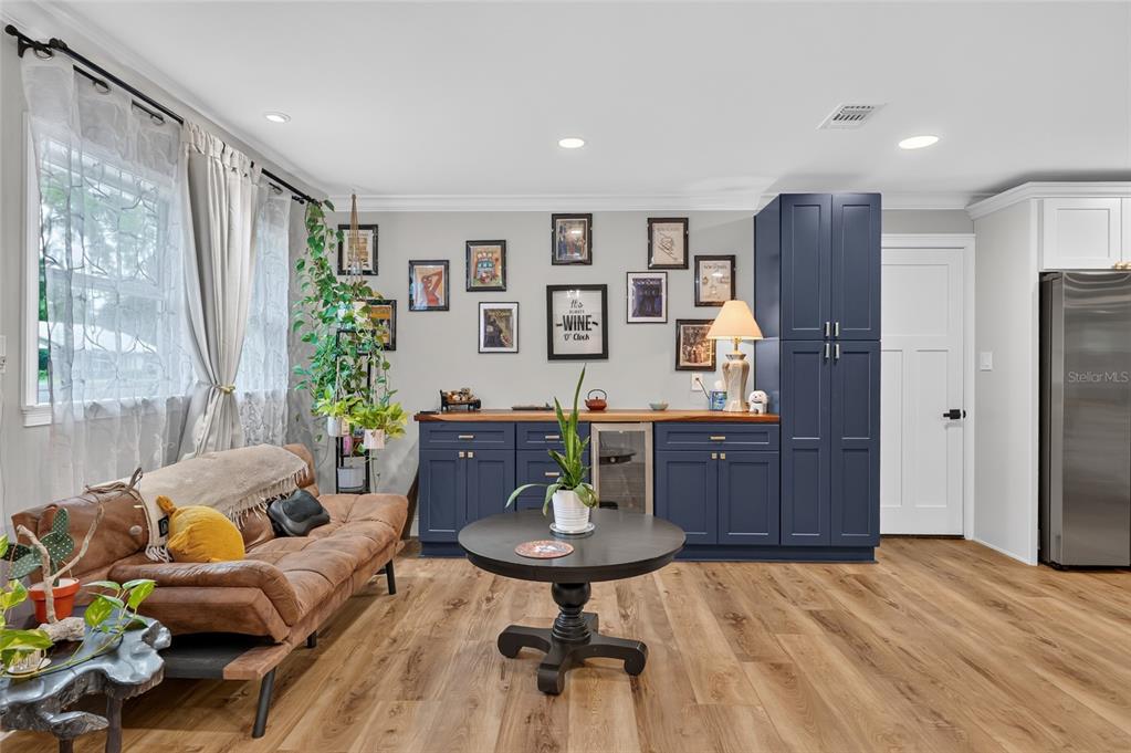 A living room features a brown sofa, a round coffee table, and dark blue cabinetry — 3862 NW 36TH PLACE, GAINESVILLE, FL
