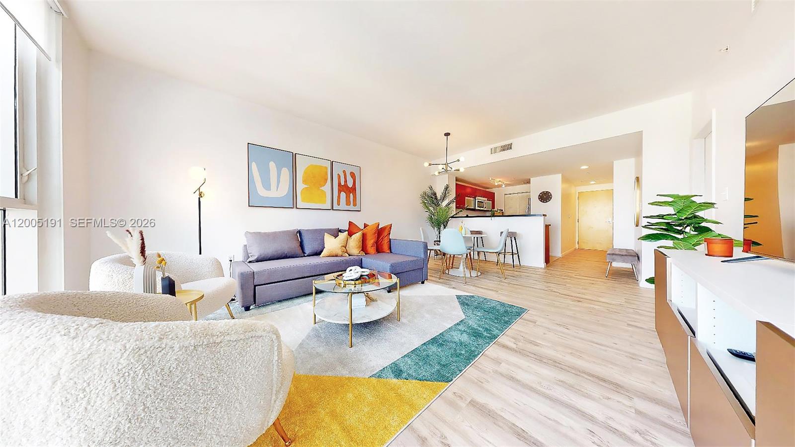 A living room features a grey sectional sofa, a geometric rug, and an open kitchen — 244 Biscayne Blvd # 704, Miami FL 33132, MIAMI, FL