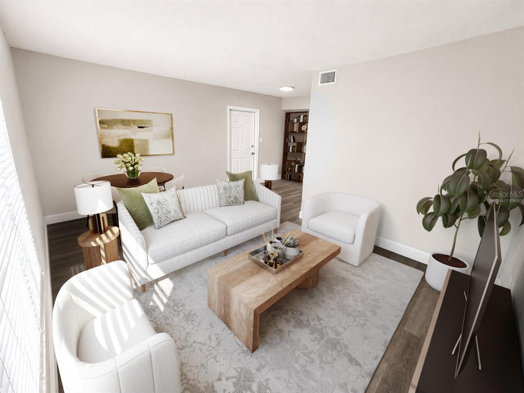 This virtually staged living room features a white sofa, two armchairs, and a wooden coffee table — 165 PICARDY VILLA CIRCLE UNIT 202, BRANDON, FL