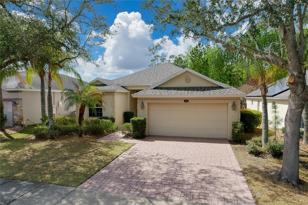 A single-story house with a beige stucco exterior, a two-car garage, and a paved driveway — 123 PRESTON AVENUE, DAVENPORT, FL
